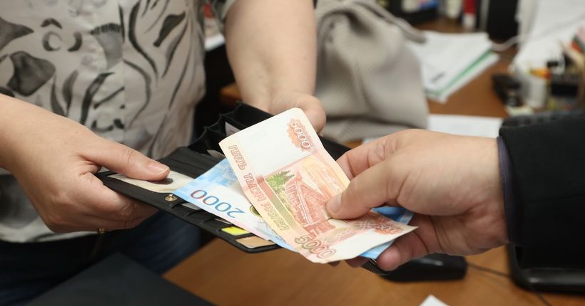 Женские руки перебирают банковские карты в кошельке
