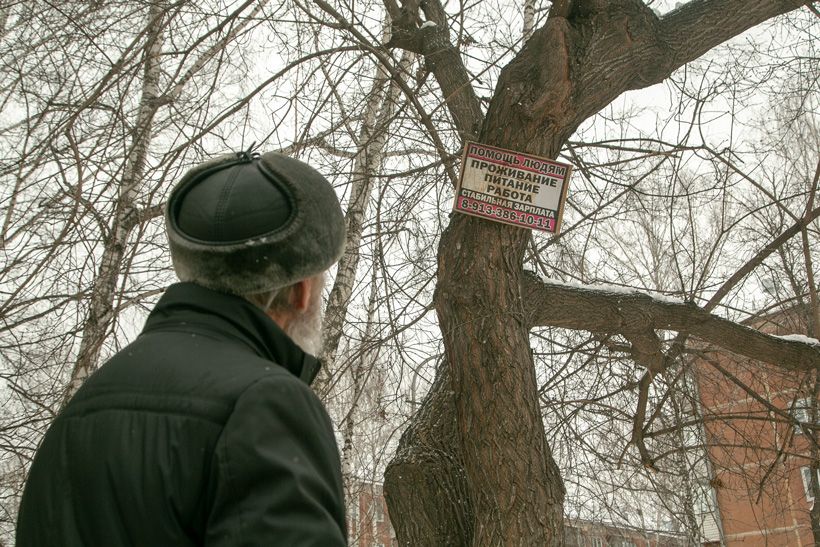 Дед разглядывает висящее на дереве объявление о помощи людям