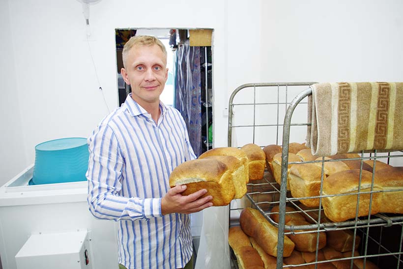Алексей Пронькин держит в руках хлеб