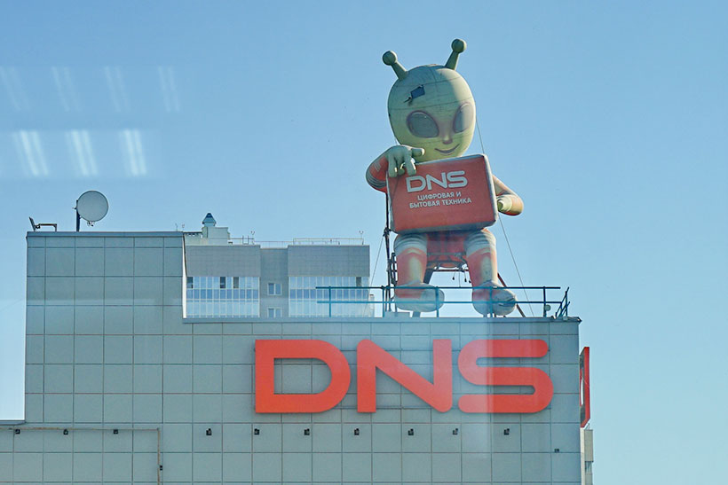 Надувная фигура зеленого инопланетянина с ноутбуком на крыше магазина бытовой техники DNS