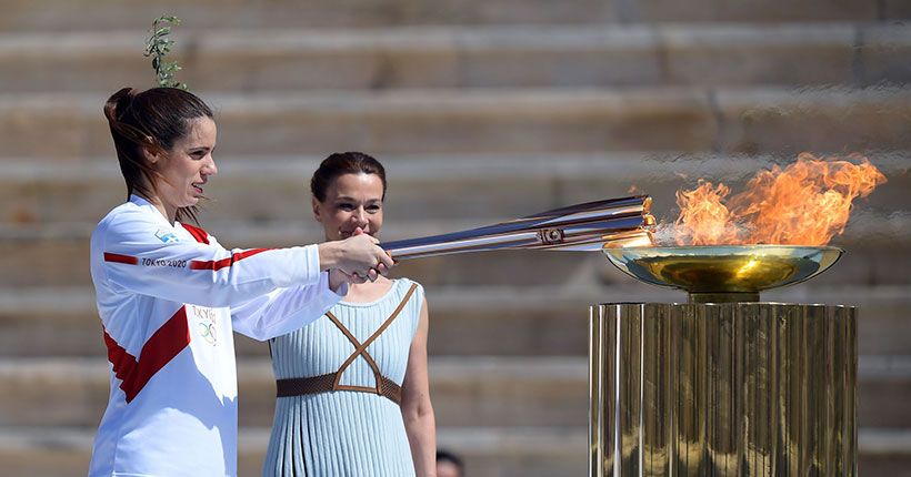 Две девушки зажигают олимпийский огонь