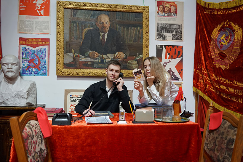 Юноша и девушка сидят за столом в музее советских экспонатов