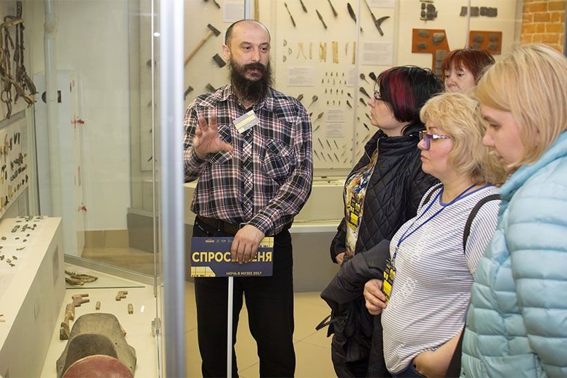 Куратор музея рассказывает посетителям об экспонате