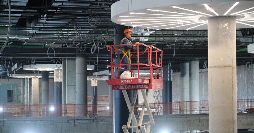 Строитель закрепляет освещение в аэропорту Толмачево