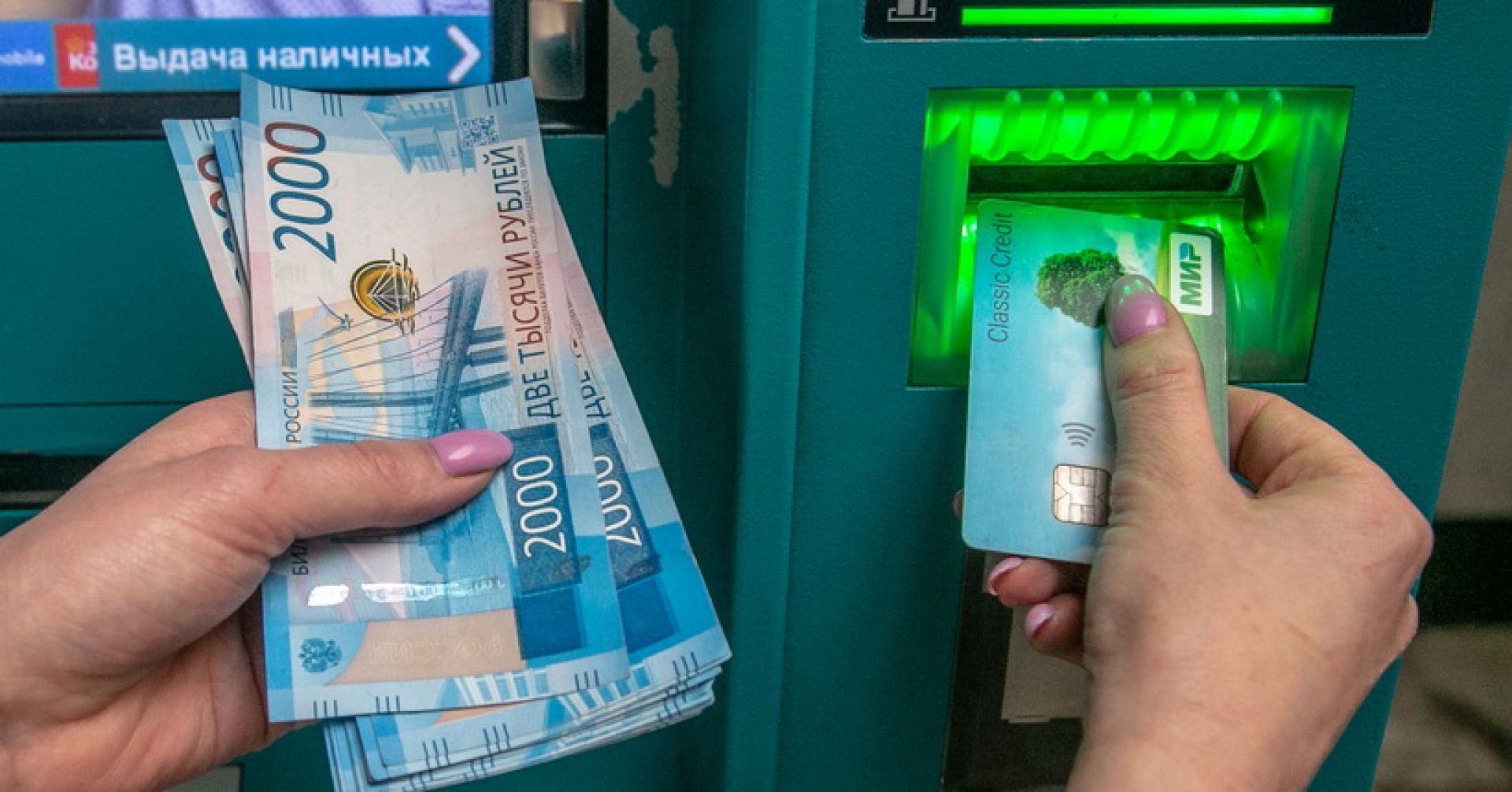 снимают деньги в банкомате