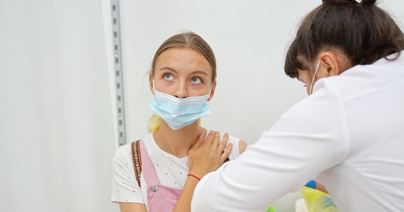 медсестра ставит девушке вакцину от коронавируса