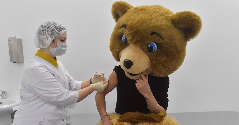 медсестра ставит прививку человеку в костюме медведя
