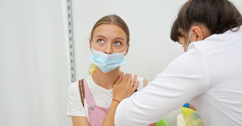 медсестра ставит вакцину девушке