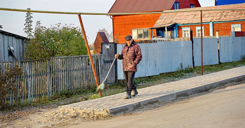 дед идёт по сельской улице с метлой