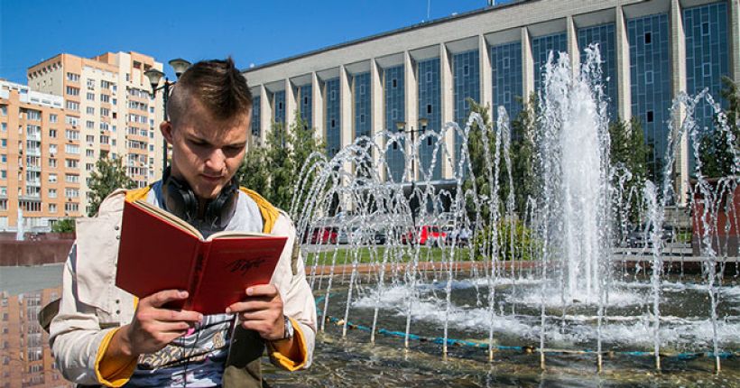 мальчик читает у фонтана