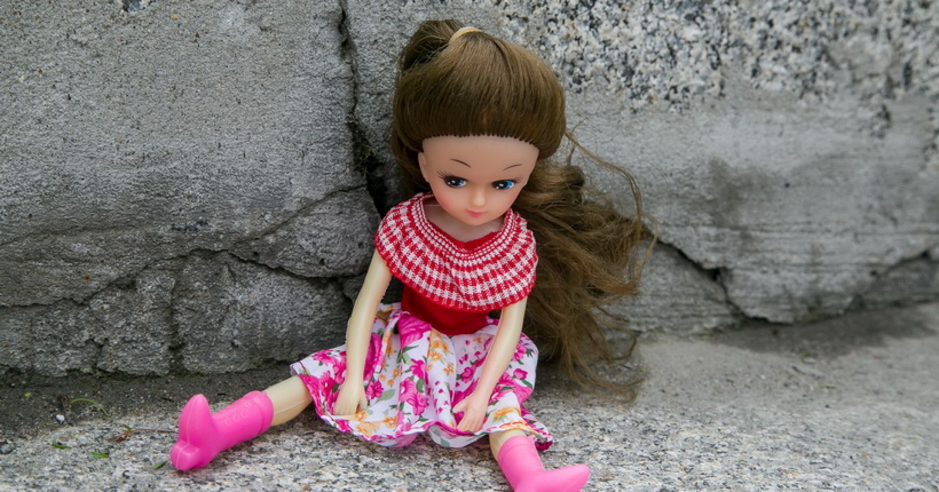 кукла сидит на асфальте