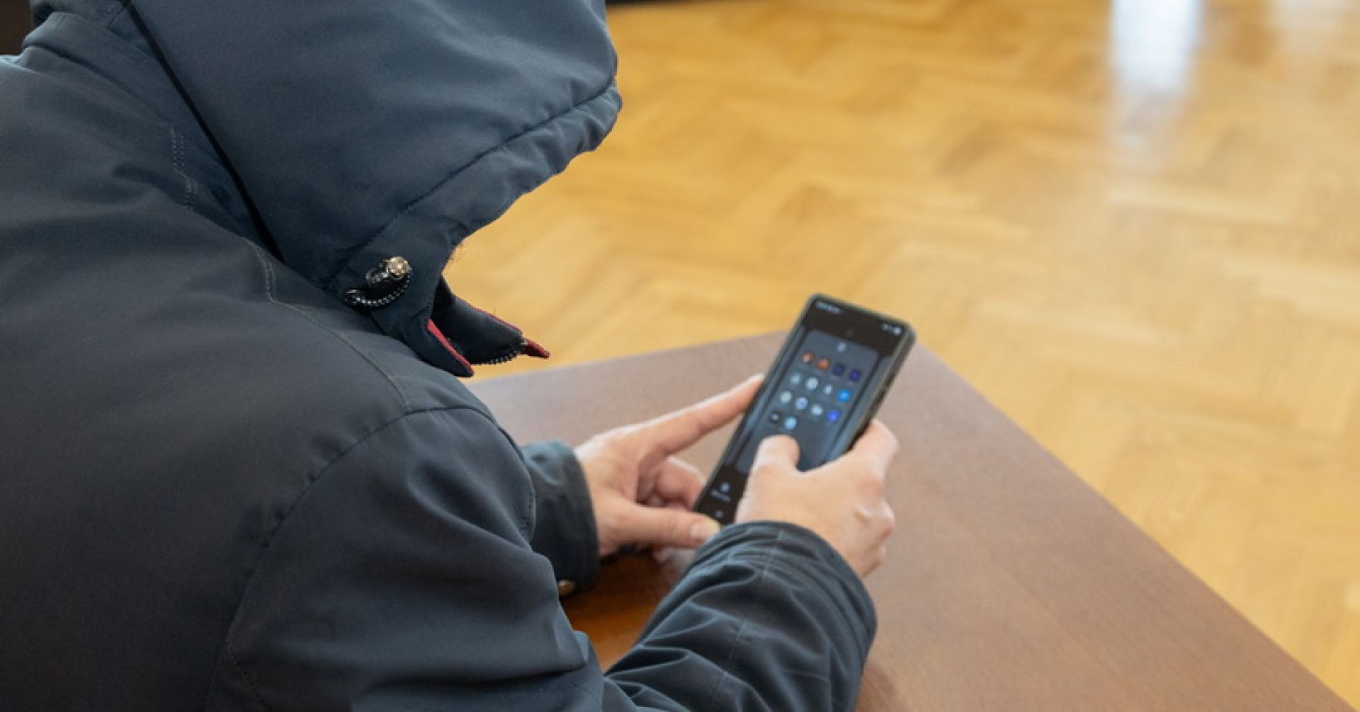 человек в капюшоне с телефоном