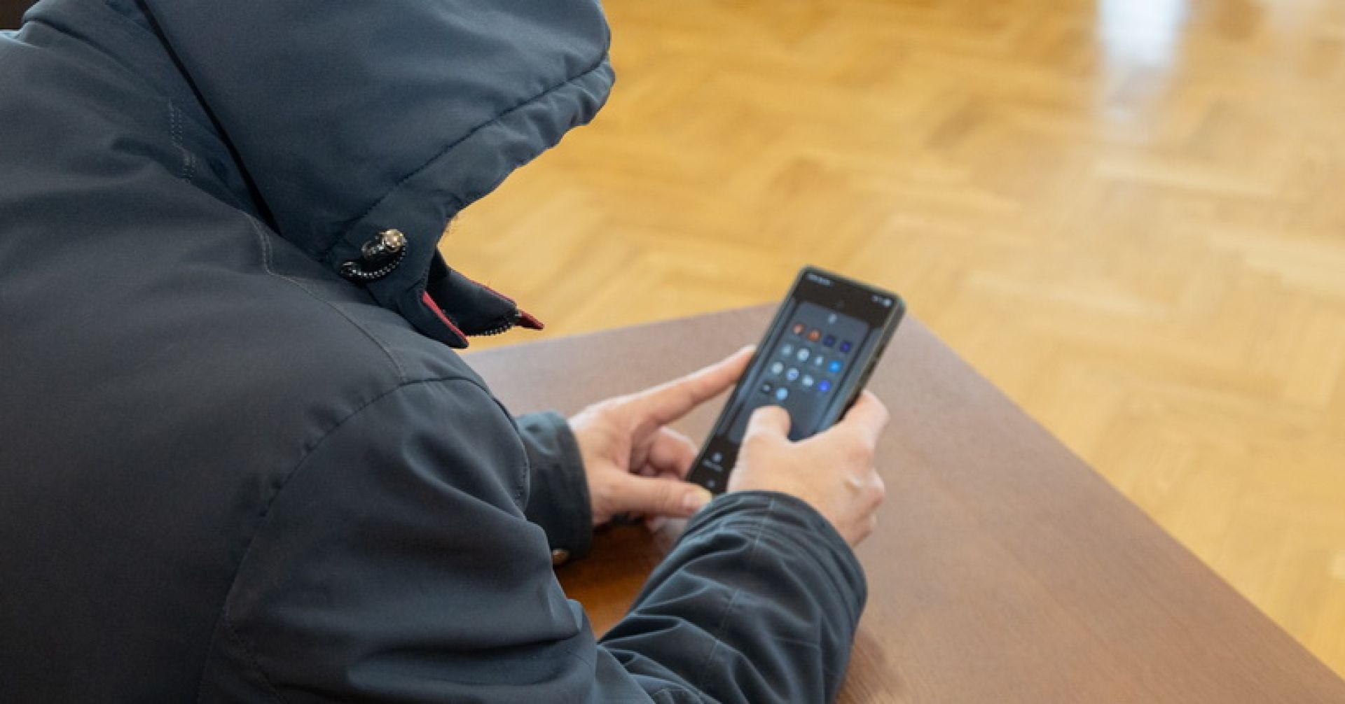 человек с телефоном в капюшоне