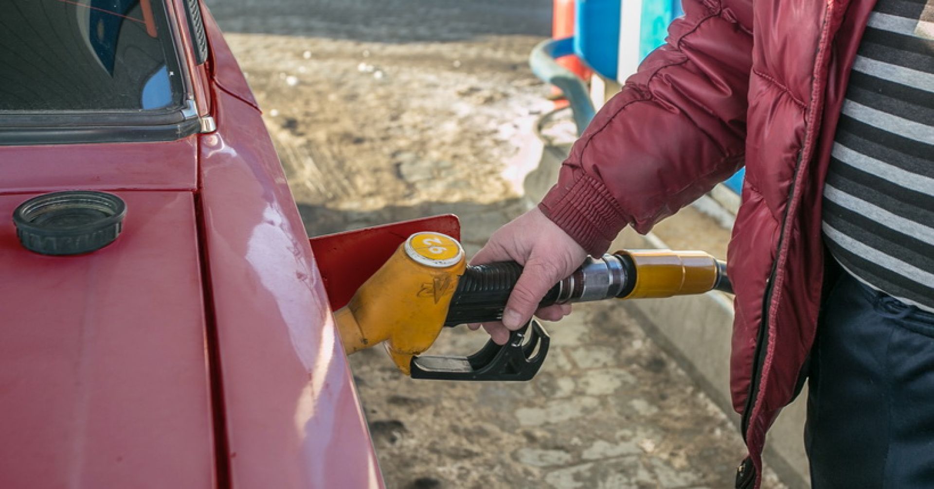 человек заправляет машину