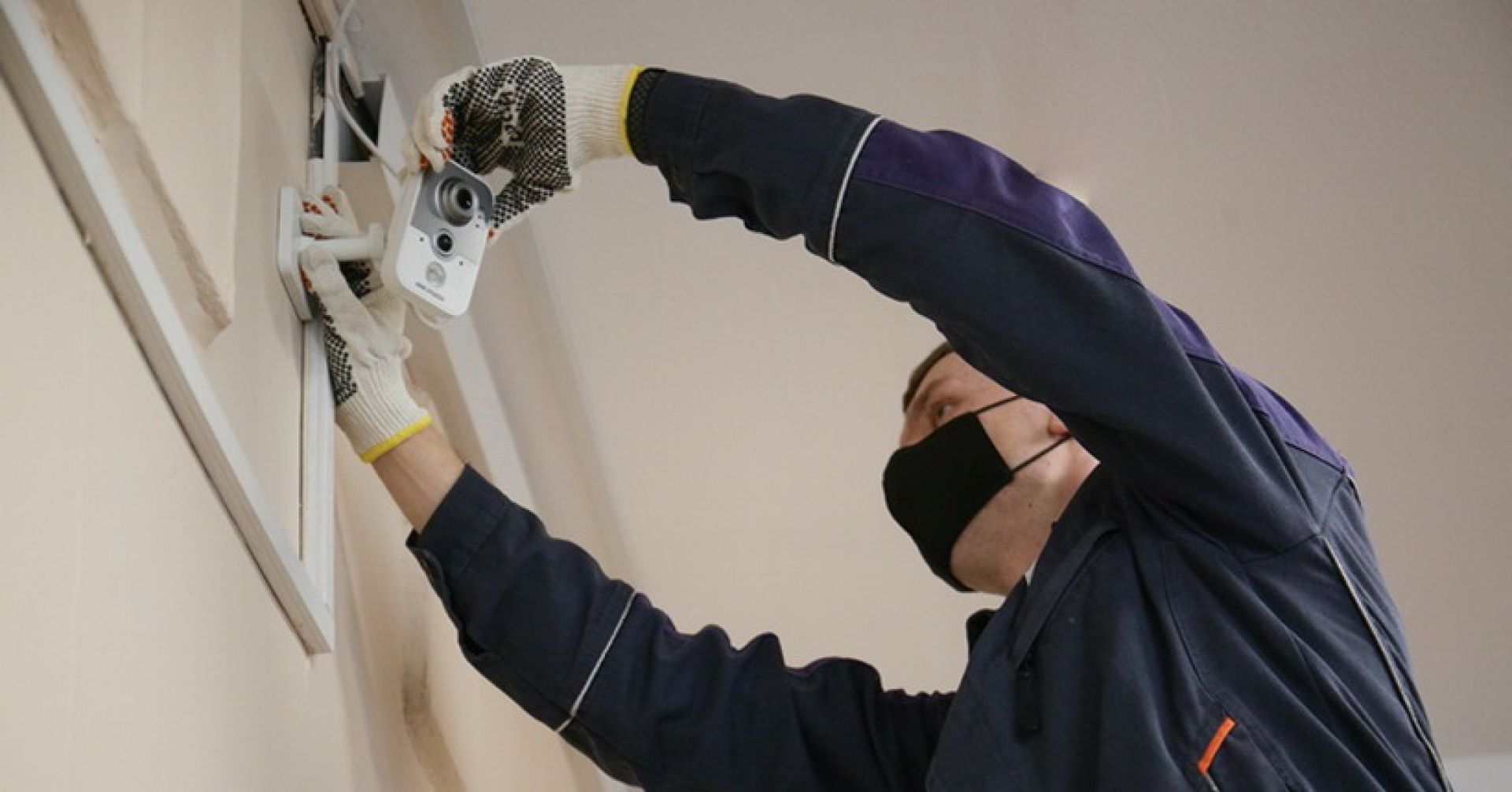 рабочий устанавливает камеру