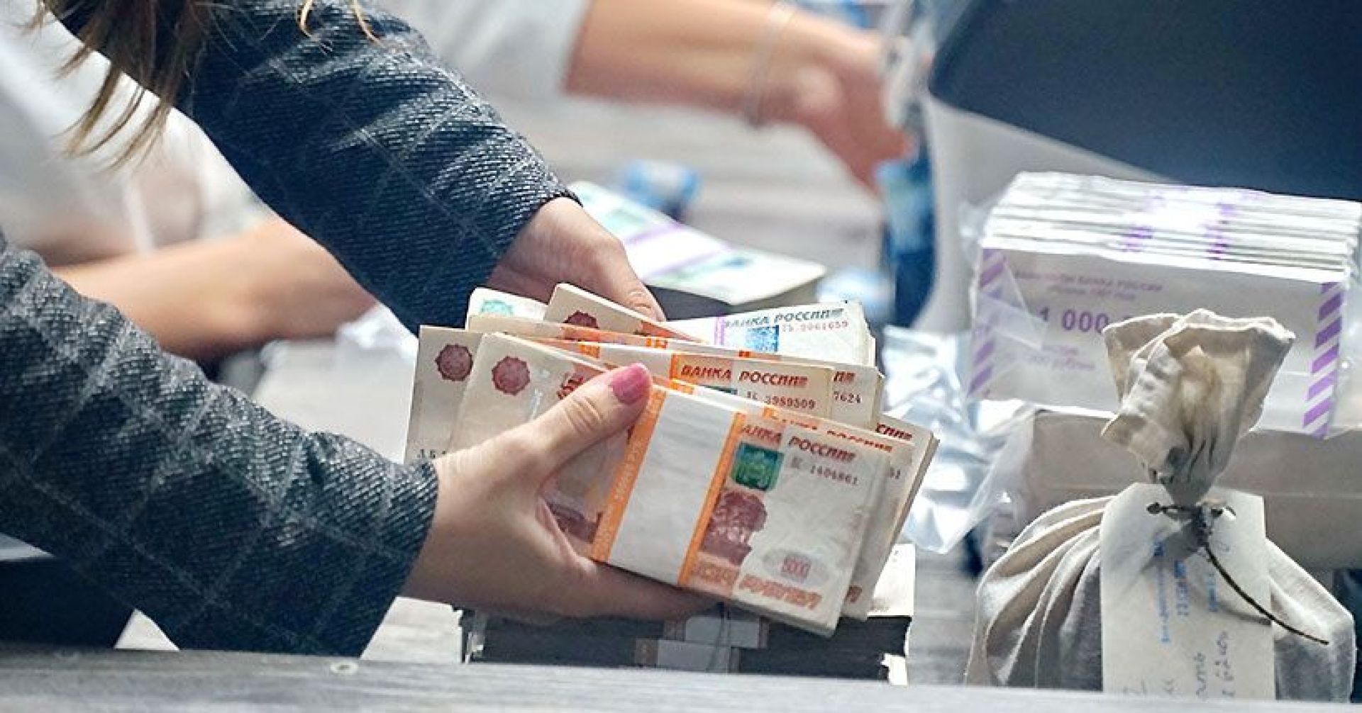 пачки денег в руках